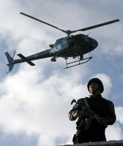 A policeman stands guard at a police station where seven Sinaloa drug cartel members are being presented to the media after they were arrested with a an arsenal of heavy weapons in Mexico City February 13, 2008. REUTERS/Stringer (MEXICO)