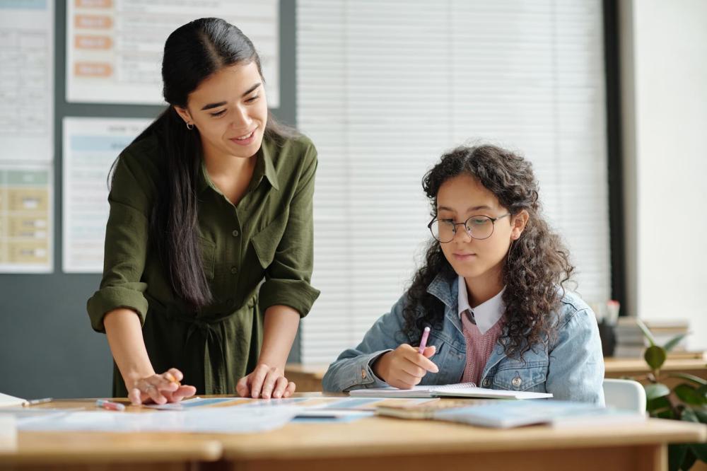 An English teacher helps her student review rules of grammar and verb conjugation.